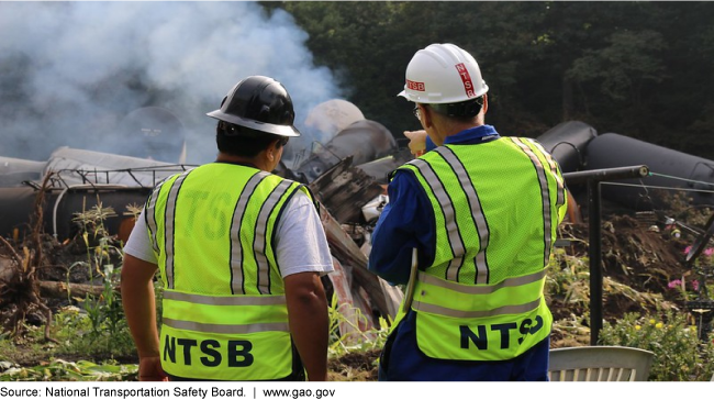 Two NTSB workers viewing smoking wreckage 