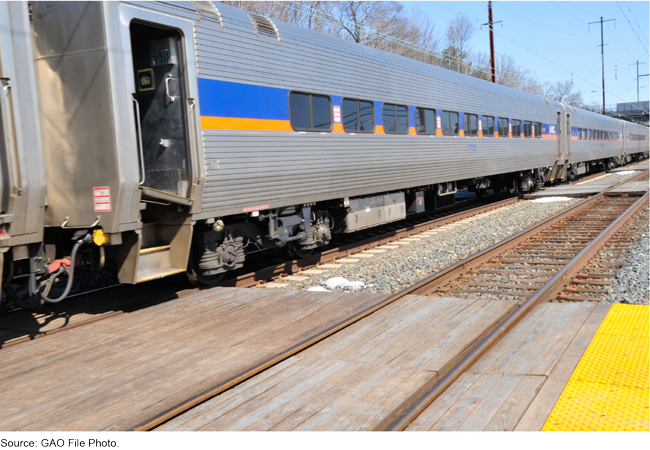 Silver colored passenger train on train tracks.