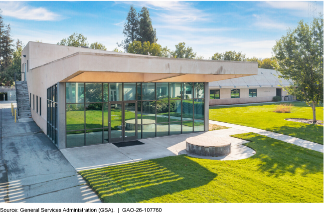 An office building with a large glass wall and a lawn. An office building with a large glass wall and a lawn.