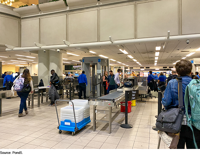 airport security checkpoint with passengers waiting in line and security agents