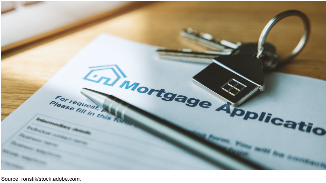 Close up of a mortgage application with a set of keys and a pen on top of it.