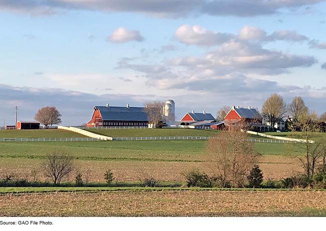 An image of farm land with barns in the distance.