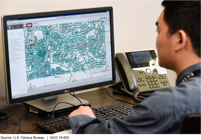 A person at a computer with a map on the monitor