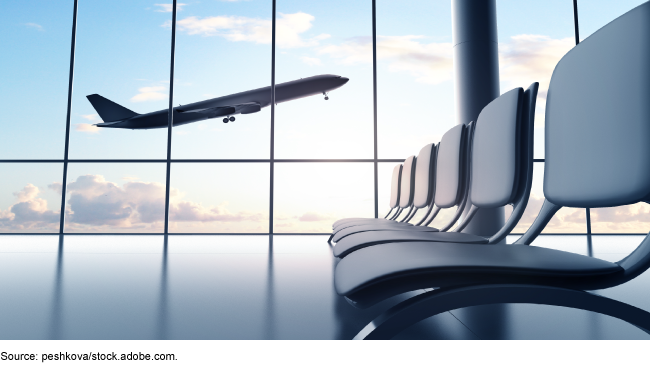 A flying airplane viewed from the window of an airport seating area. A flying airplane viewed from the window of an airport seating area.