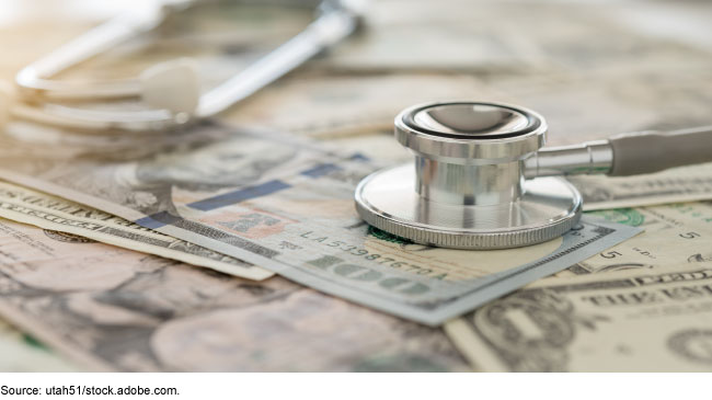 A stethoscope laying on top of cash.