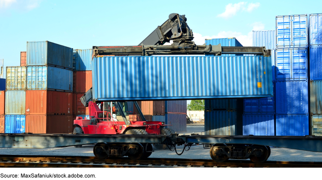 Freight container being loaded onto a train car