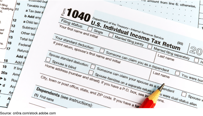Two pages of a paper copy of the individual tax form 1040 and a pencil.