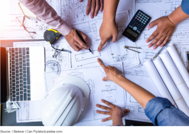 Overhead view of people pointing to technical drawing
