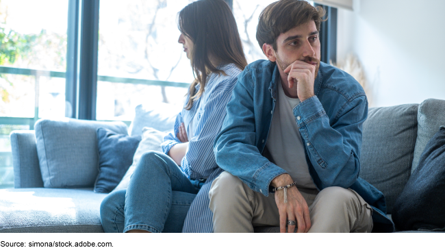 Couple sitting back-to-back on a sofa. Couple sitting back-to-back on a sofa.