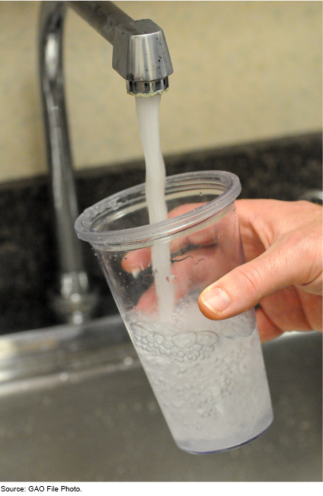 Photo of a cup under a running faucet.