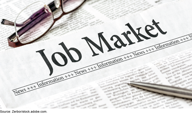  A newspaper with the headline Job Market, with a silver pen and a pair of eyeglasses on top of the paper