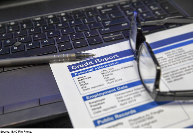 An image of a paper credit report laying on a laptop keyboard.
