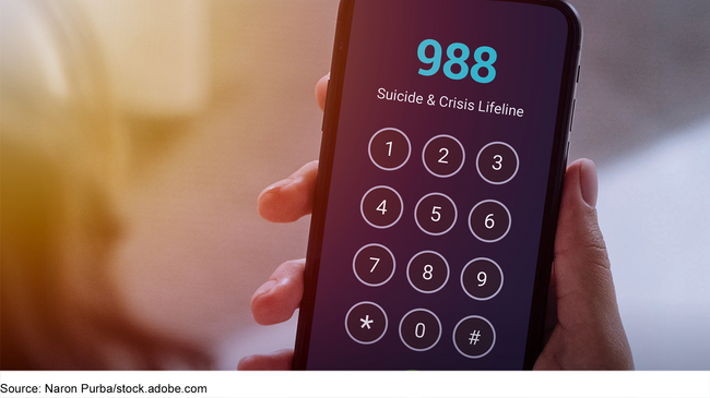 Hand holding a mobile phone with the 988 Suicide & Crisis Lifeline on the screen. Hand holding a mobile phone with the 988 Suicide & Crisis Lifeline on the screen.