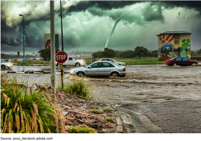 Cars in a flooded road with storm clouds in the background and a tornado. Cars in a flooded road with storm clouds in the background and a tornado.