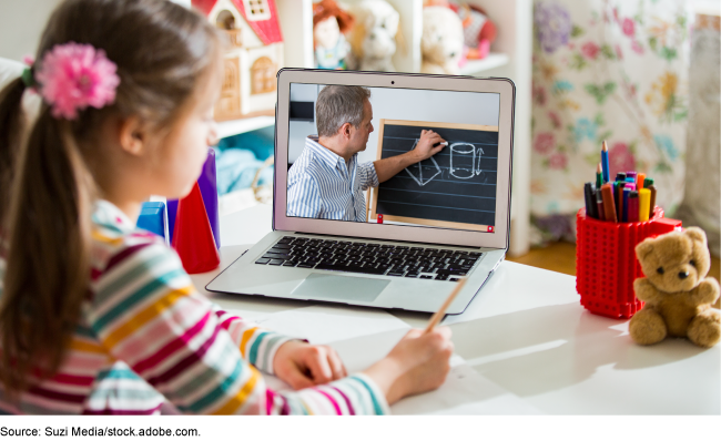 A young student learning virtually via a laptop.