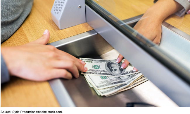 Bank teller dispensing money.