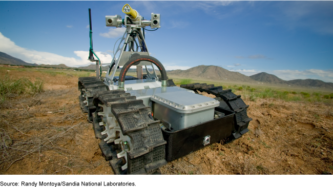 A robot in the foreground with mountains and sky in the background