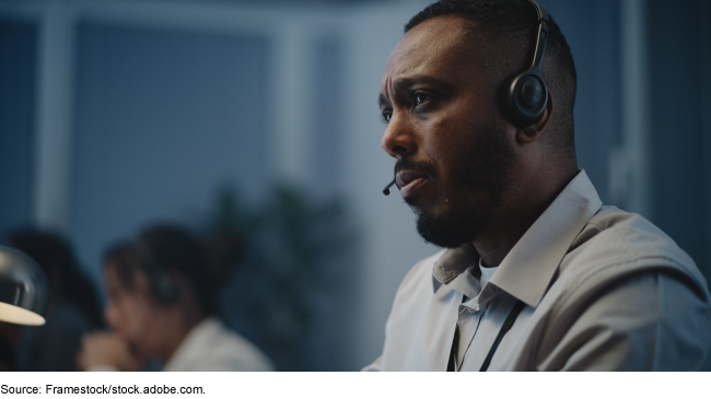 A person with a headset for phone calls looking concerned and listening.