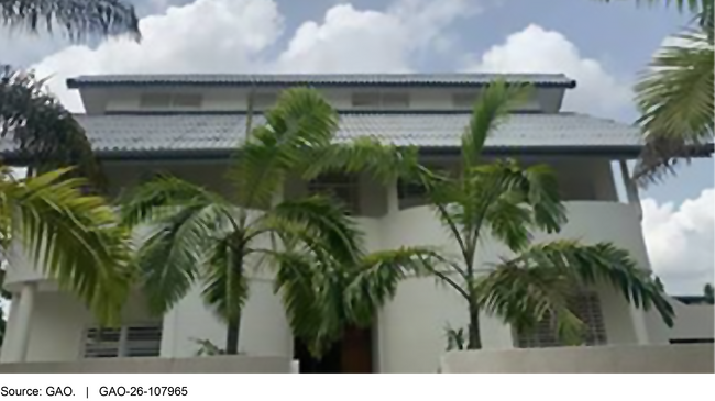 A house and palm trees with a blue sky in the background. A house and palm trees with a blue sky in the background.