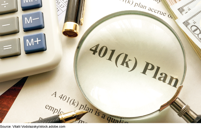 Magnifying glass focused on the words 401(k) Plan. Desktop items, including a calculator, pens, and paper.