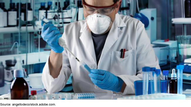 Researcher pipetting test tube to take samples in research laboratory