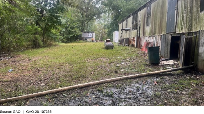 A home with a pipe extending from the foundation that carries untreated wastewater.