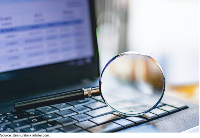 Magnifying glass on a laptop keyboard. Magnifying glass on a laptop keyboard.