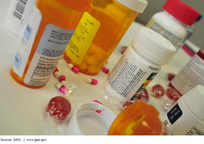 Pills and pill bottles scattered on a white surface