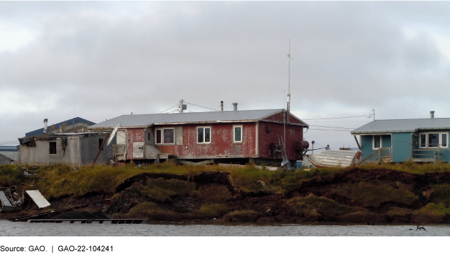 Homes sitting on hill above a body of water.