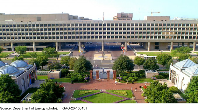 An elevated building with lots of windows surrounded by other buildings next to a street. An elevated building with lots of windows surrounded by other buildings next to a street.