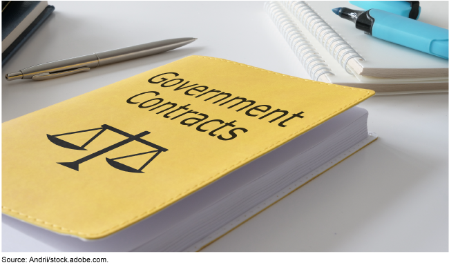 A book titled Government Contracts, on a table with pens and notebooks. A book titled Government Contracts, on a table with pens and notebooks.