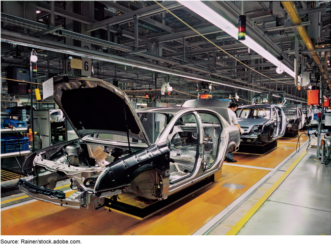 A car frame being built on a manufacturing assembly line.