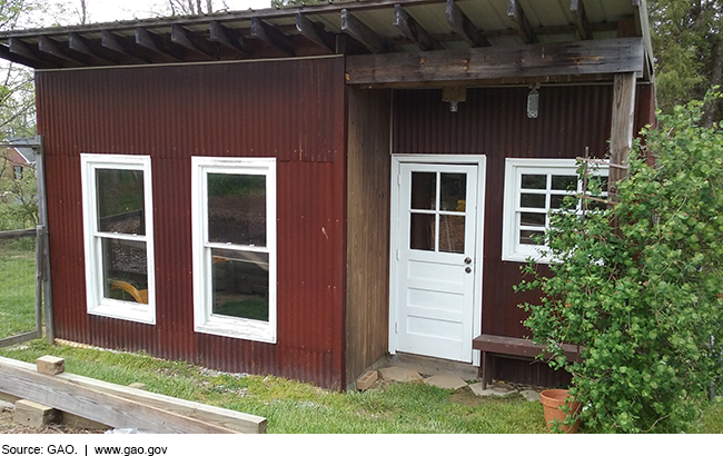 Photo of a large wooden shed with windows and doors.