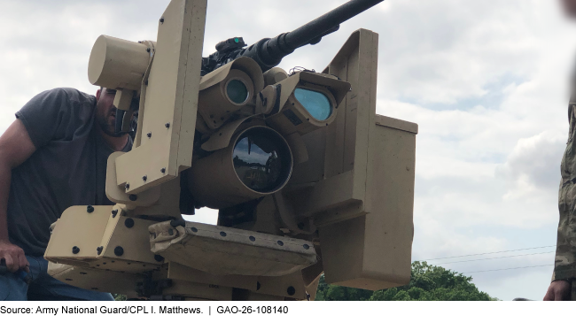 A person looking into a military machine that has a gun on top and a few different sized lenses.