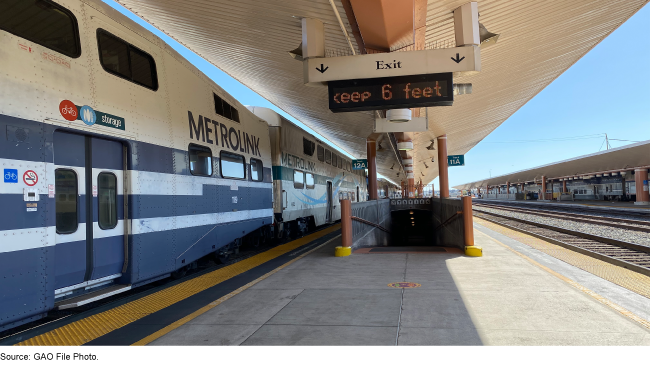 A commuter rail station with a train waiting for passengers