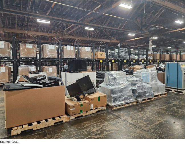 A warehouse full of cardboard boxes and computer equipment wrapped in plastic on pallets. A warehouse full of cardboard boxes and computer equipment wrapped in plastic on pallets.