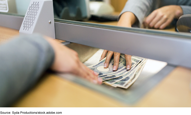 A cash transaction at a bank teller window