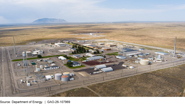 A plot of land with several buildings, storage units, and silos.  