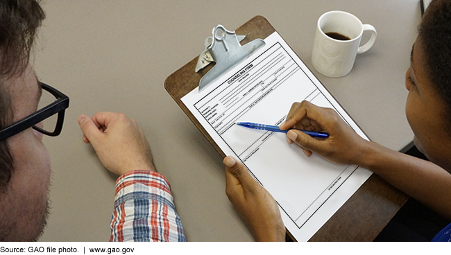 Two people reviewing a counseling form on a clipboard