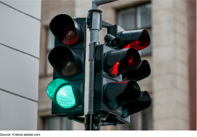 A traffic light at an intersection, green in one direction and red in the other. A traffic light at an intersection, green in one direction and red in the other.