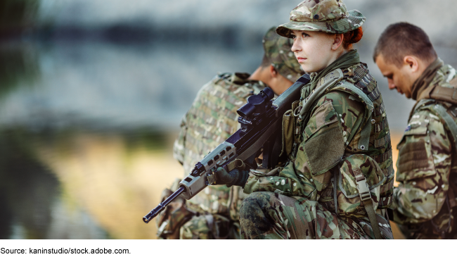 A picture of a woman military servicemember in uniform, holding a rifle.
