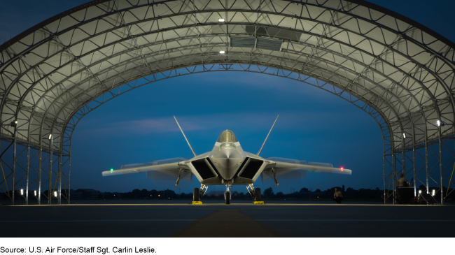 An Air Force F-22 raptor lit for night maintenance