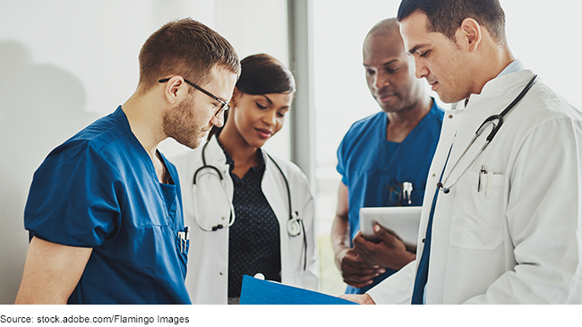 Group of four physicians looking at a medical file.