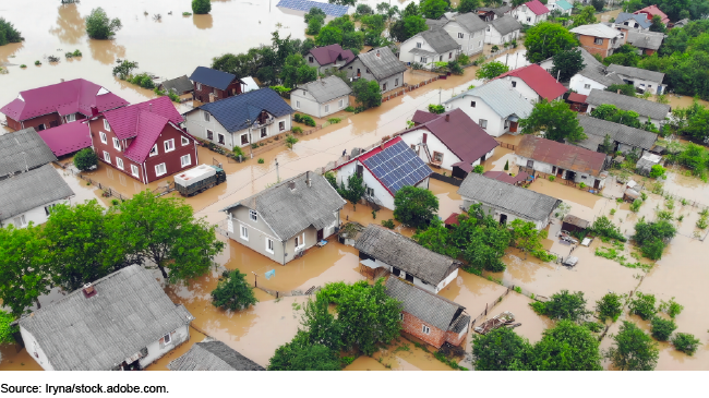 Aerial image showing a flooded residential neighborhood with homes and gardens submerged. Aerial image showing a flooded residential neighborhood with homes and gardens submerged.