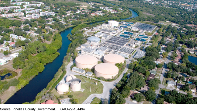 aerial view of a waterway, a water facility, houses, and trees