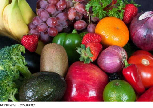 A pile of different types of fruits and vegetables, including grapes, strawberries, and broccoli, among others.