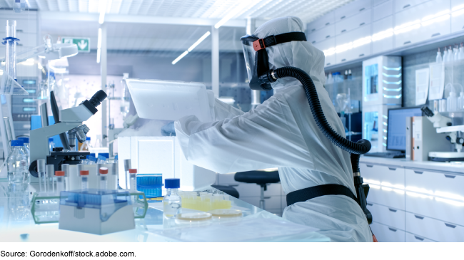A person wears protective gear while working in a biological research lab. 