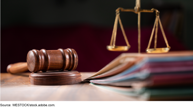 Gavel and scales of justice on a wood table with file folders
