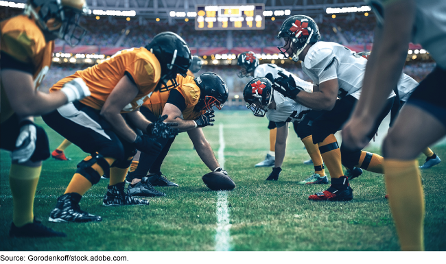 Football teams face each other in the middle of a football field.