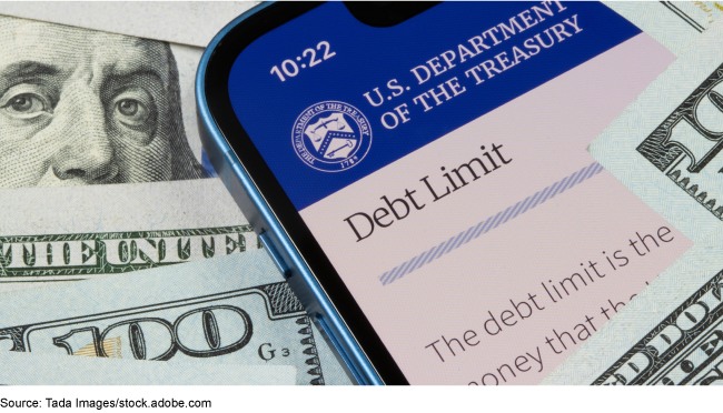 A smartphone showing a web page on the debt limit from the U.S. Department of the Treasury's website, on top of a few $100 bills. A smartphone showing a web page on the debt limit from the U.S. Department of the Treasury's website, on top of a few $100 bills.